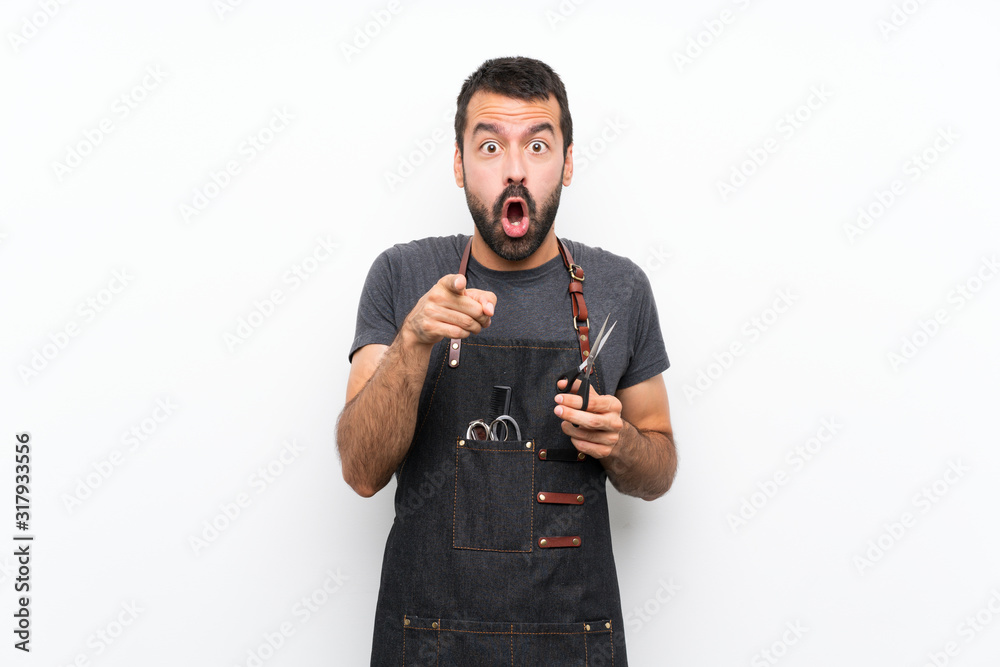 Barber man in an apron surprised and pointing front Barber man in an apron surprised and pointing front