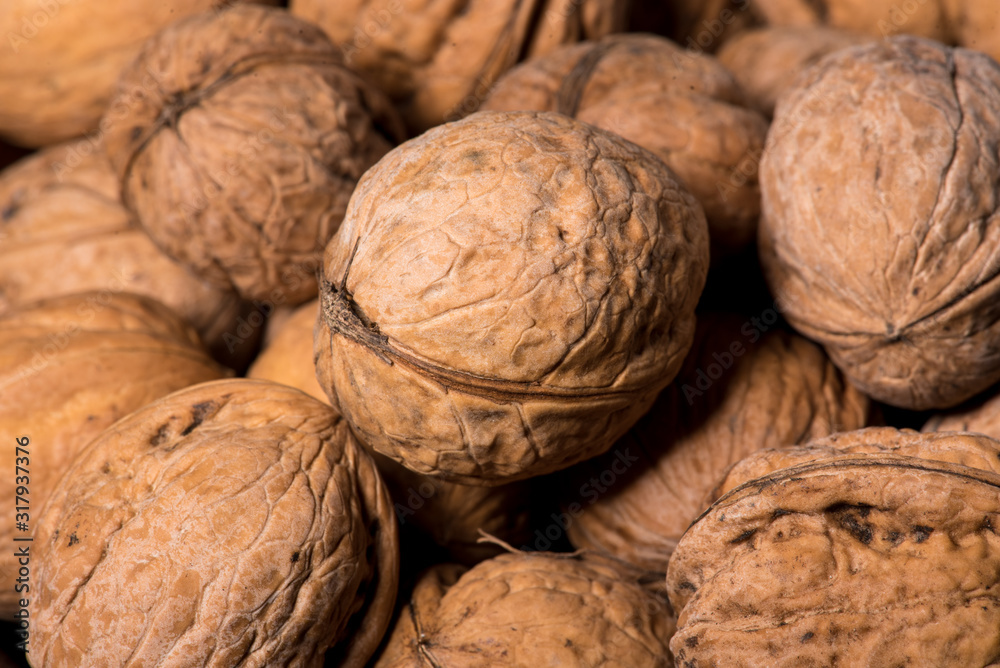 Walnut kernels in basket and whole walnuts on rustic old wood Walnut kernels in basket and whole walnuts on rustic old wood