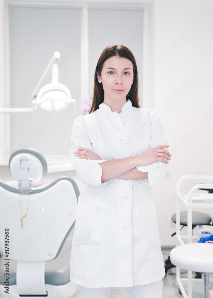 Portrait of female dentist doctor in white uniform at workplace, close-up. Portrait of female dentist doctor in white uniform at workplace, close-up.