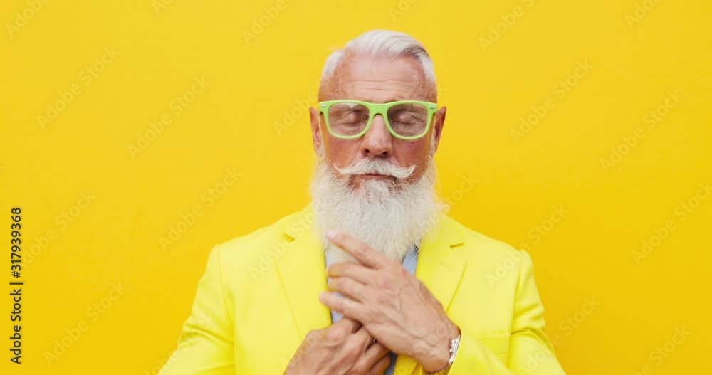 Senior man hipster with funny colored outfit on colored backgrounds