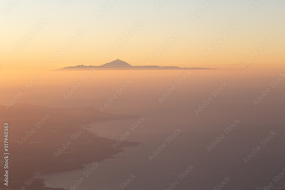 Wonderful aerial views at sunset of el Teide seen from Gran Canaria, Tenerife, Canary Islands, Spain. .The highest mountain in Spain. Canary islands concept. Wonderful aerial views at sunset of el Teide seen from Gran Canaria, Tenerife, Canary Islands, Spain. .The highest mountain in Spain. Canary islands concept.