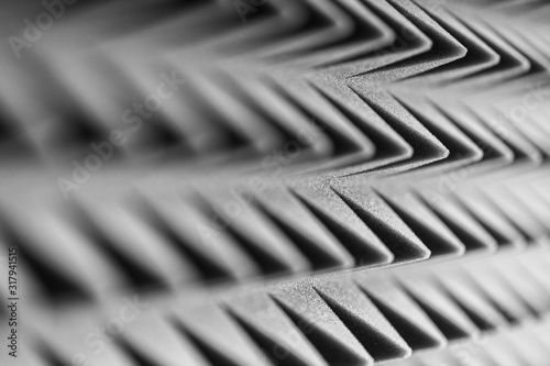 Grey acoustic foam pyramid repeating background for music Studio. Black and white. Close-up view with shallow depth of field