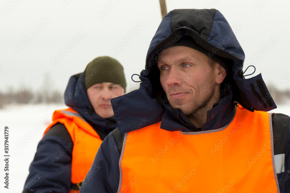 Portrait of an installer in a blue jacket and orange vest Portrait of an installer in a blue jacket and orange vest