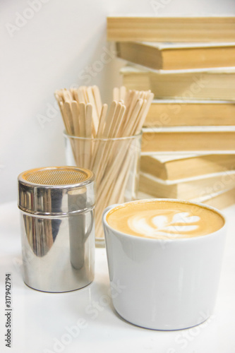 coffee with heart pattern, sticks, сinnamon, books