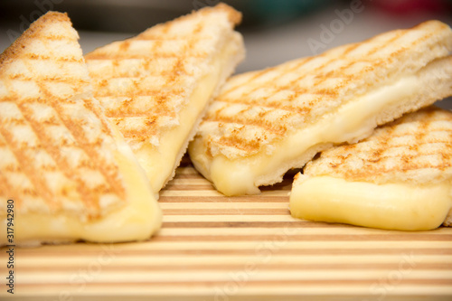 cheesy club sandwiches on a wooden chopping board