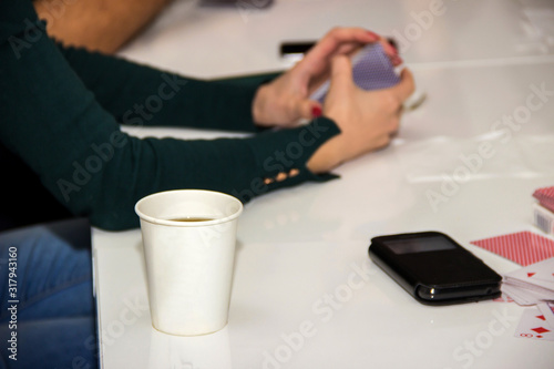 paper cup for coffee tea stands near playing cards