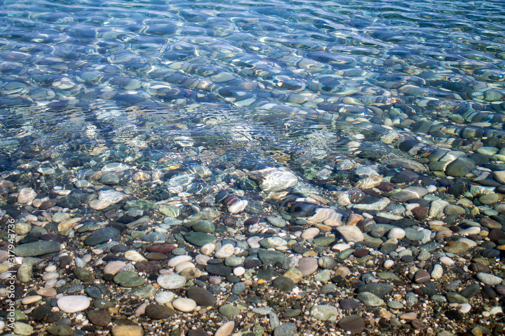 Sea stones in sea water. Pebbles under water. The view from the top. Nautical background. Clean sea water. Transparent sea Sea stones in sea water. Pebbles under water. The view from the top. Nautical background. Clean sea water. Transparent sea