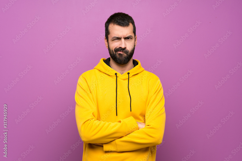 Handsome man with yellow sweatshirt with sad and depressed expression Handsome man with yellow sweatshirt with sad and depressed expression
