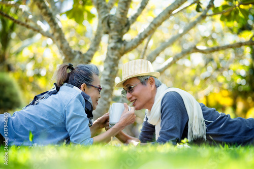 Happy asian couple senior elderly retire drinking coffee and working in park and relax time. Family elderly the rest after retirement in vacations.Senior elderly planning for retirement savings
