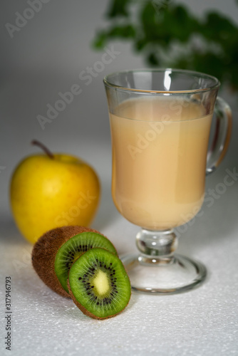 Juicy smoothie from apples and kiwi in a glass cup on a white background