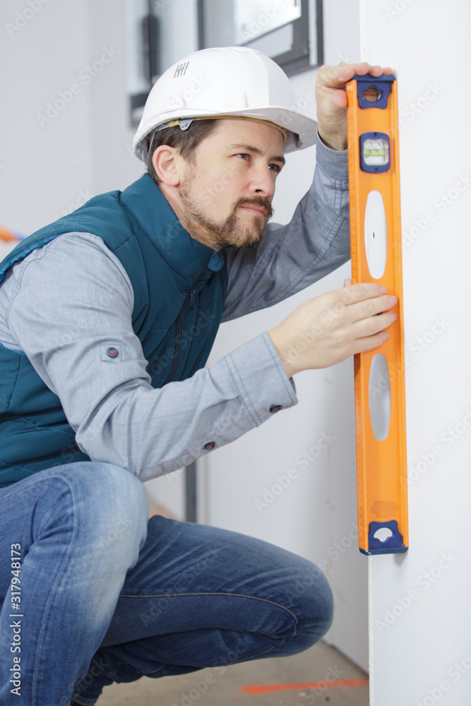 worker is using a level indoors worker is using a level indoors