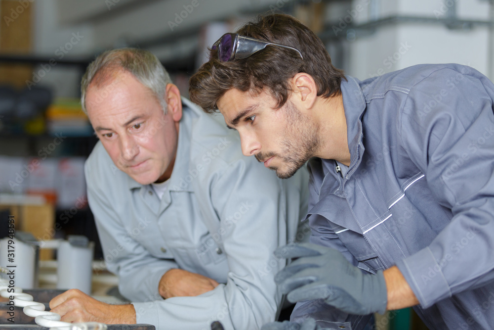Obraz premium young machinist and his trainer performing a task