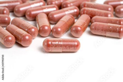 Red yeast rice supplement capsules on white background photo
