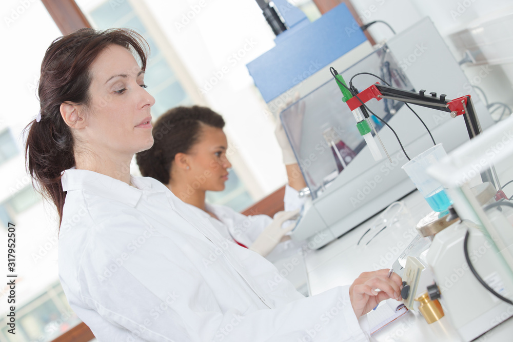 side view of female scientists at work in a laboratory side view of female scientists at work in a laboratory