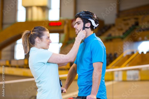 woman putting helmet to cyclist