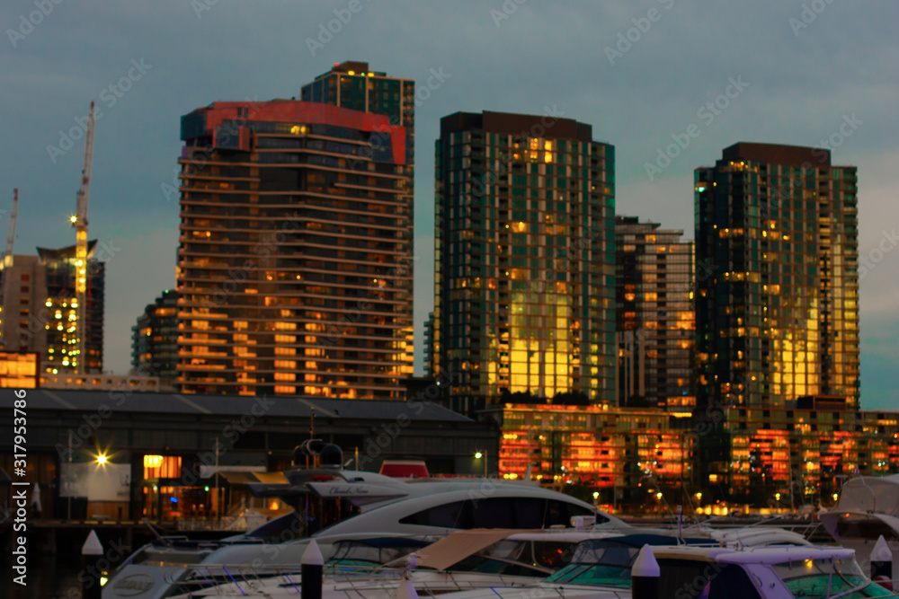 Fototapeta premium A view of the night Melbourne. Quay in Docklands, view from the bay to the skyscrapers with yachts in the foreground.