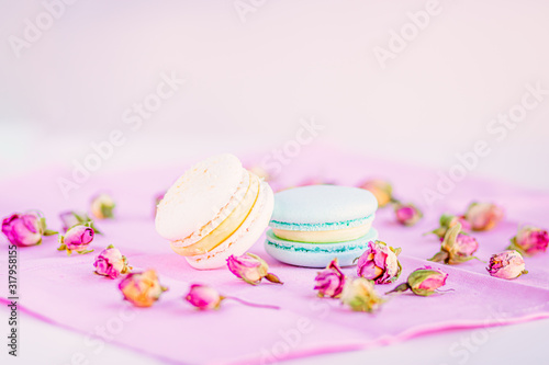Selective focus on macarons with cream and the buds of dried roses.