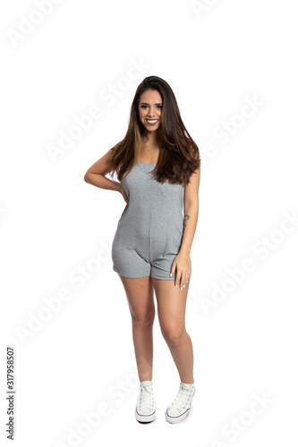 Well-dressed model portrait of smiling girl in casual pretty clothes.  Brunette lovely lady on white background. Happiness, positivity and fashion