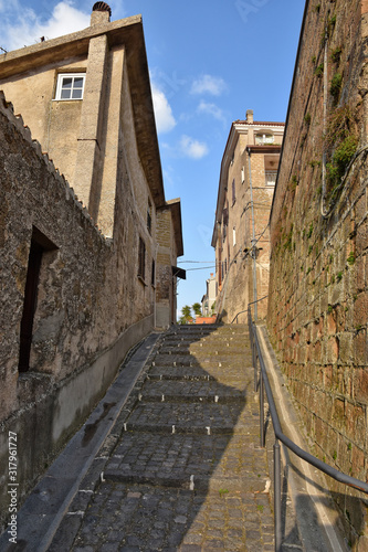 A narrow street between the old houses of a mountain village  Italy