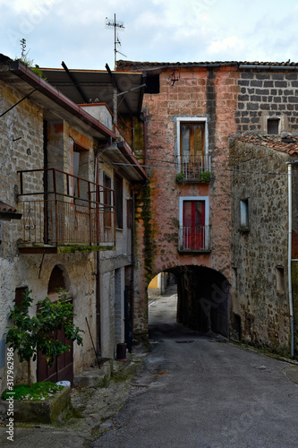 A narrow street between the old houses of a mountain village, Italy