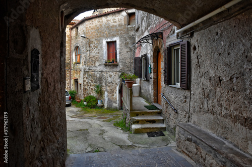 Fototapeta Naklejka Na Ścianę i Meble -  A narrow street between the old houses of a mountain village, Italy