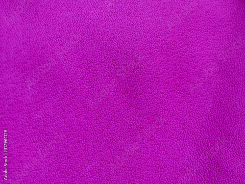 Background with leather texture. Violet piece of natural tanned calfskin painted and treated with fuchsin paint. Lots of detail, frontal shot with macro lens. Copyspace for border or frame
