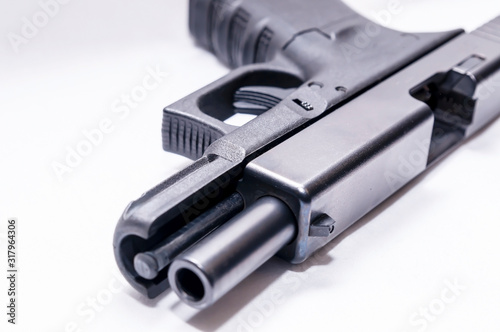 A black 9mm semi automatic pistol with an opened slide on a white background 