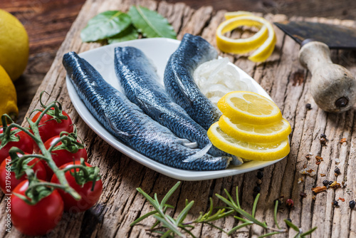 Fototapeta Naklejka Na Ścianę i Meble -  Close-up of fresh marinated fish served with onions on a rustic wooden table