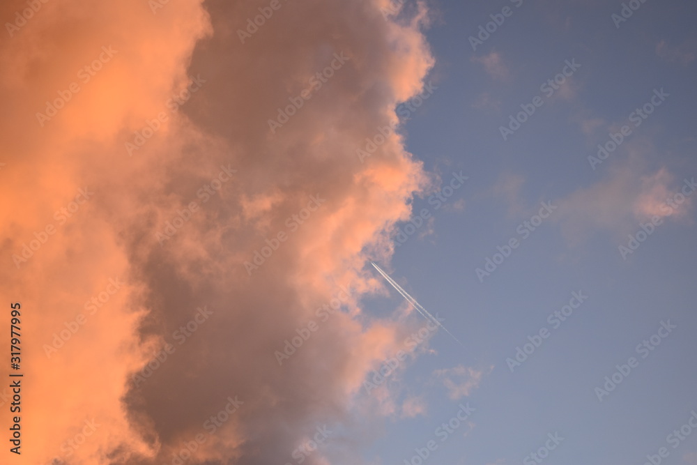 Pink clouds with aircraft trail
