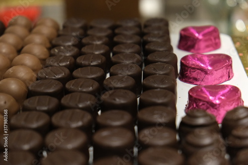 Assorted candies in the candy store. Chocolate cookies and pink heart