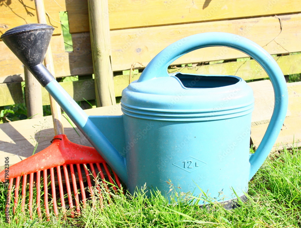 arrosoir ,et râteau ,outils de jardinage isolé dans le jardin arrosoir ,et râteau ,outils de jardinage isolé dans le jardin