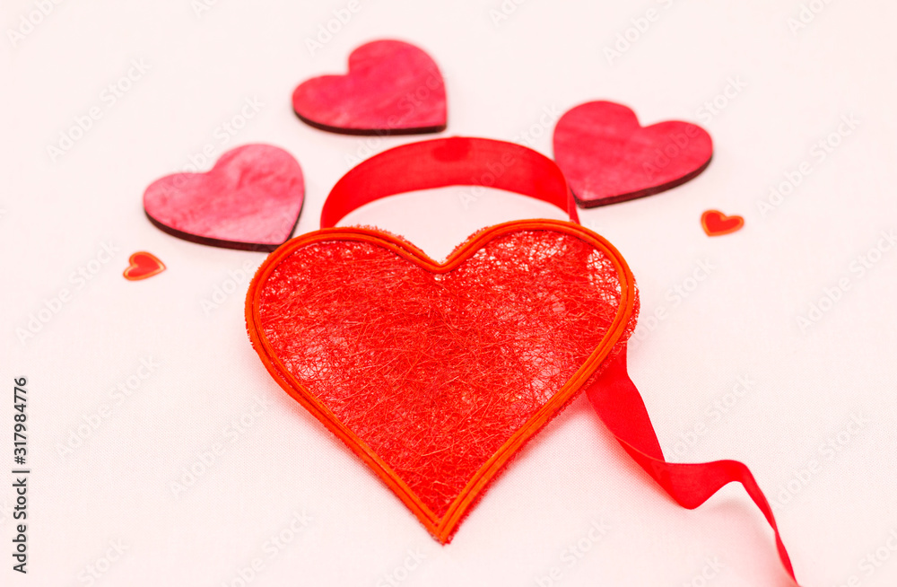 beautiful red heart decorated with ribbon on a light background