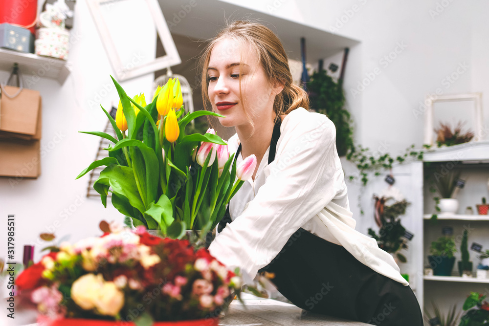 Flower shop seller sniffs tulips. Florist in flower market