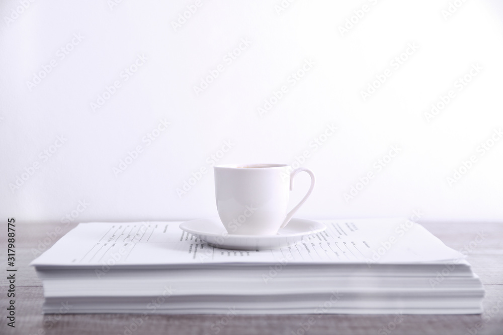 Take a break drink coffee concept. Cup of coffee on a stack of paper on the table Take a break drink coffee concept. Cup of coffee on a stack of paper on the table
