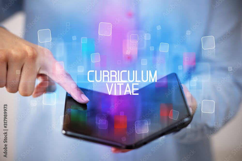 Young man holding a foldable smartphone with CURRICULUM VITAE inscription, educational concept Young man holding a foldable smartphone with CURRICULUM VITAE inscription, educational concept