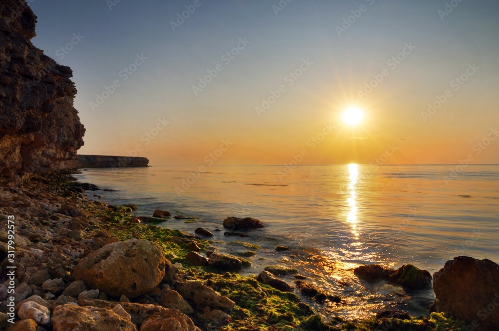 Beautiful golden sunset over Black sea rocky coastline in Crimea Beautiful golden sunset over Black sea rocky coastline in Crimea