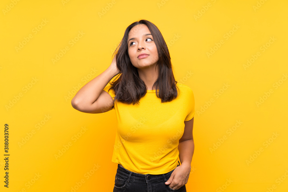 Young brunette girl over isolated background having doubts Young brunette girl over isolated background having doubts