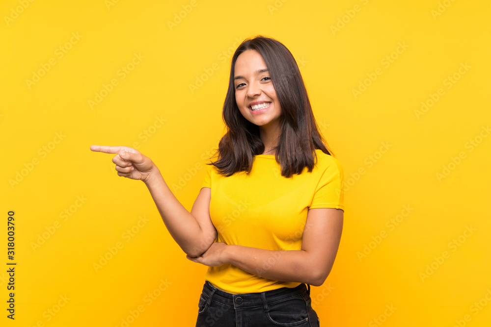 Young brunette girl over isolated background pointing finger to the side Young brunette girl over isolated background pointing finger to the side