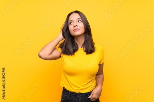 Young brunette girl over isolated background having doubts