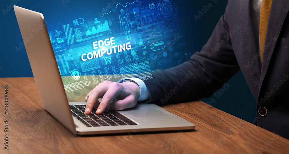 Businessman working on laptop with EDGE COMPUTING inscription, cyber technology concept Businessman working on laptop with EDGE COMPUTING inscription, cyber technology concept