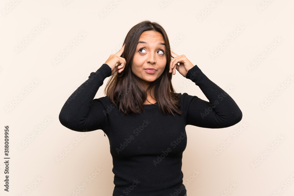 Young brunette woman with white sweater over isolated background having doubts and thinking Young brunette woman with white sweater over isolated background having doubts and thinking