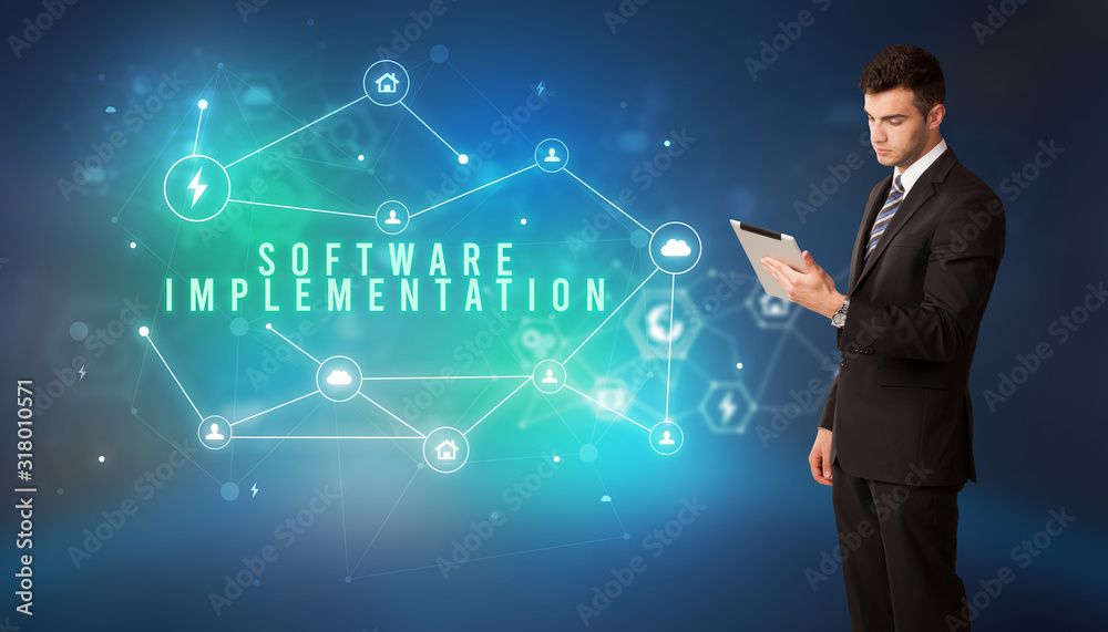 Businessman in front of cloud service icons with SOFTWARE IMPLEMENTATION inscription, modern technology concept Businessman in front of cloud service icons with SOFTWARE IMPLEMENTATION inscription, modern technology concept