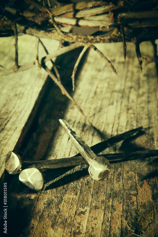 Crown of thorns and nails again vintage wooden background as symbol of crucifixion of Jesus Christ.