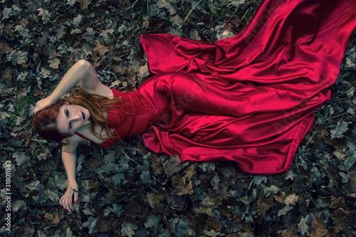 Obraz na plátne beautiful girl lie on a ground in red dress