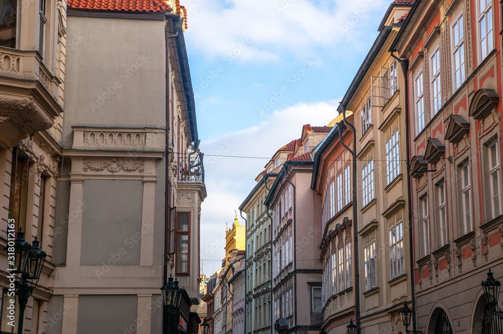 Alleyway next to the old town square in Prague. Historical building facades in beautiful colours and blue sky.