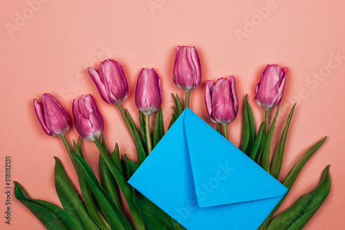pink tulips and blue envelope on pink background. womens day card