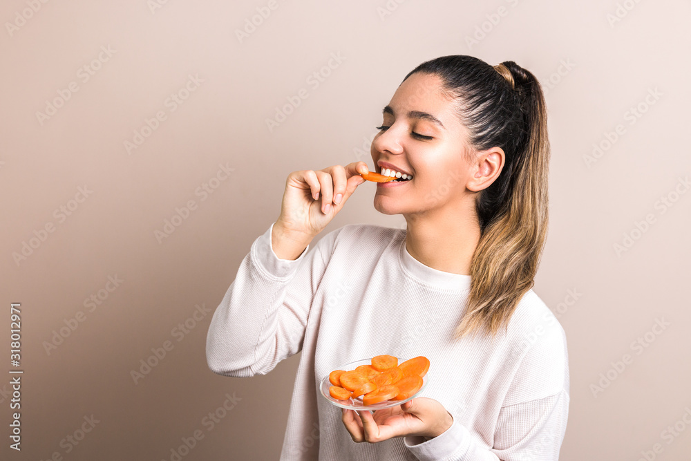 beautiful woman with smile on her face and eyes closed enjoying eating carrot. healthy organic food concept beautiful woman with smile on her face and eyes closed enjoying eating carrot. healthy organic food concept