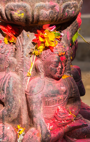 Hinduist sculpture covered in color powder at the Uma Maheshwor temple in Kirtipur, Nepal photo