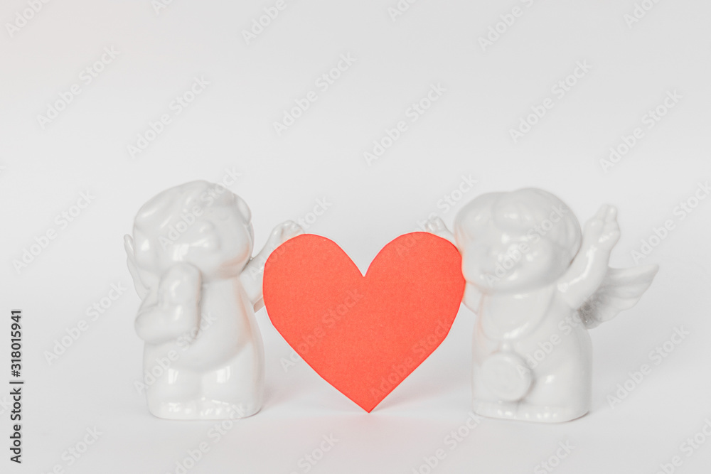 Ceramic figurines on a white background and hearts in blur . Valentine's Day. Selective focus. Ceramic figurines on a white background and hearts in blur . Valentine's Day. Selective focus.
