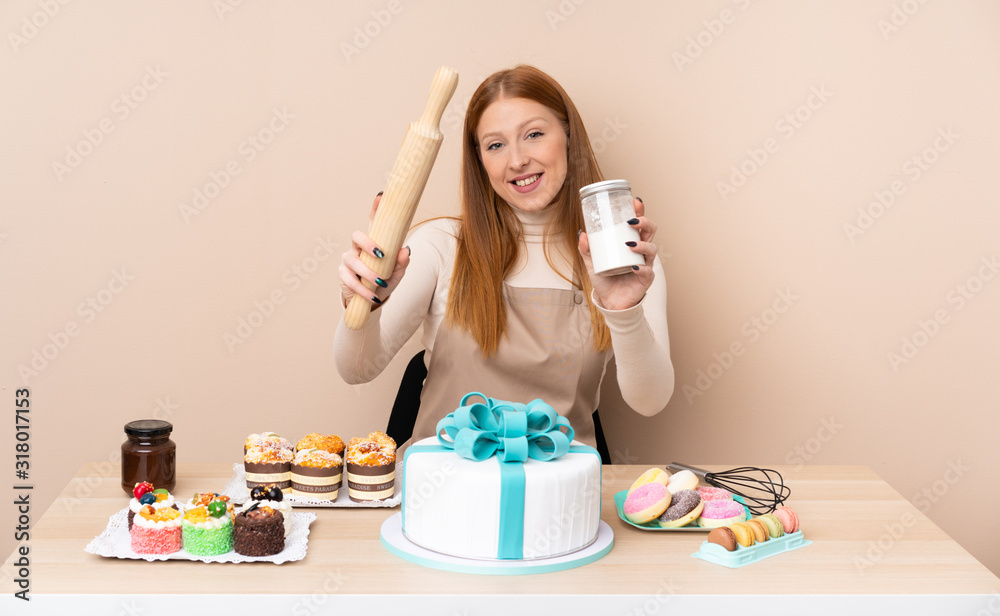 Young redhead woman with a big cake